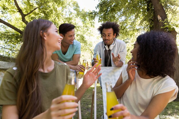 陽気な若い多民族の友人の学生屋外ジュースを飲む