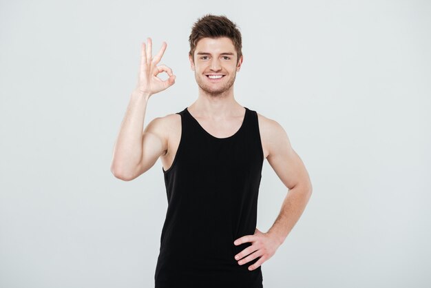 Cheerful young sportsman showing okay gesture.