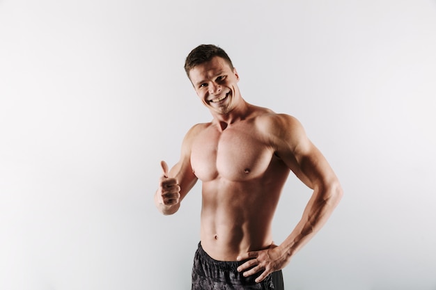 Cheerful young sportsman showing thumbs up