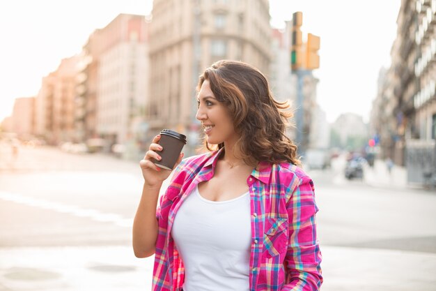 Cheerful young woman enjoying coffee and summer