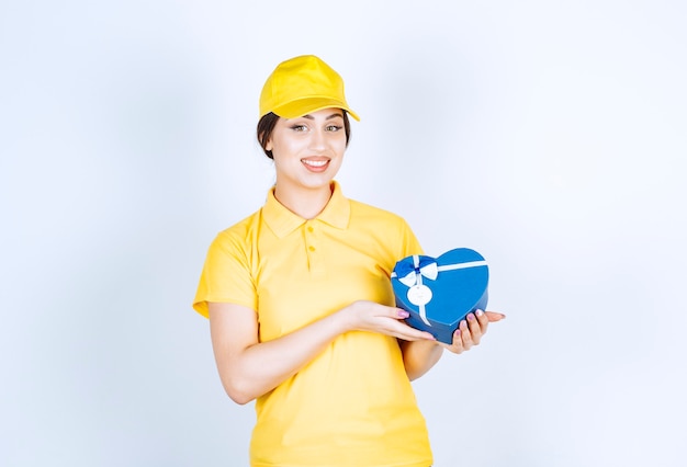 Cheerful young woman holding box and looking at front