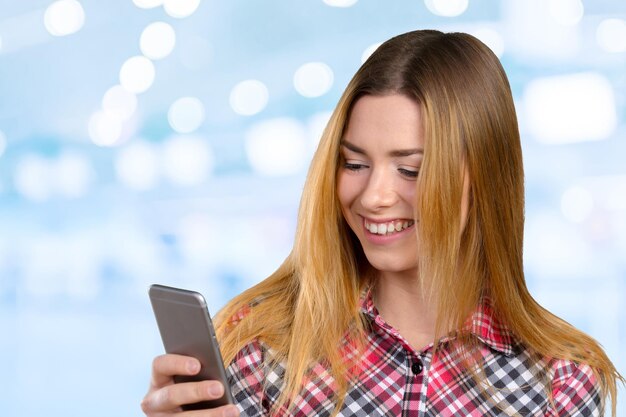 Cheerful young woman holding mobile phone