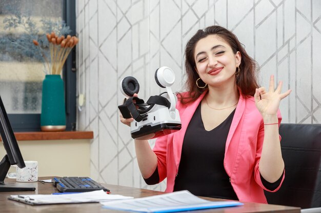 Cheerful young woman holding VR glasses and shaking her hand High quality photo