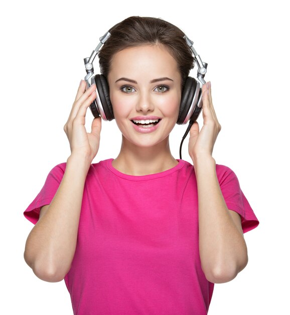 Cheerful young woman listening music with headphones