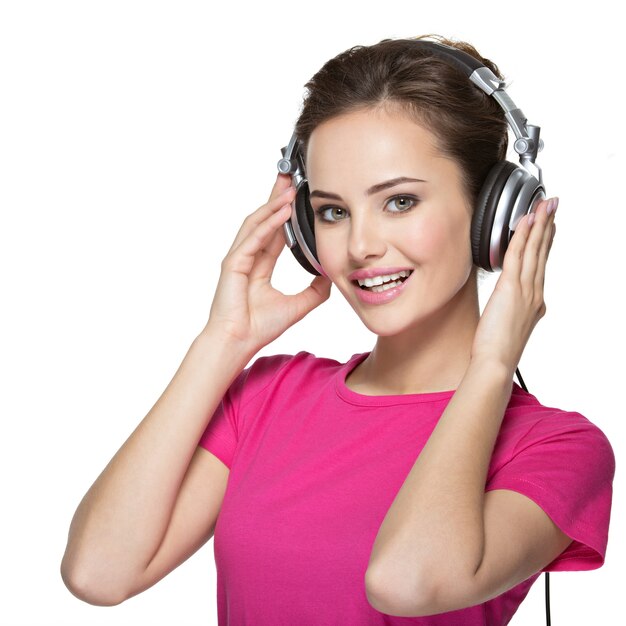 Cheerful young woman listening music with headphones