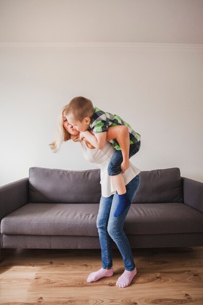 Cheerful young woman playing with her son