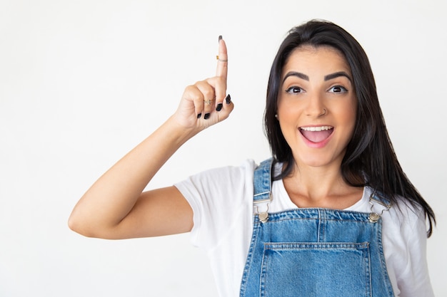 Cheerful young woman pointing up with finger