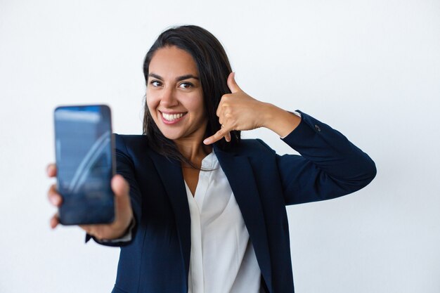 Cheerful young woman showing smartphone