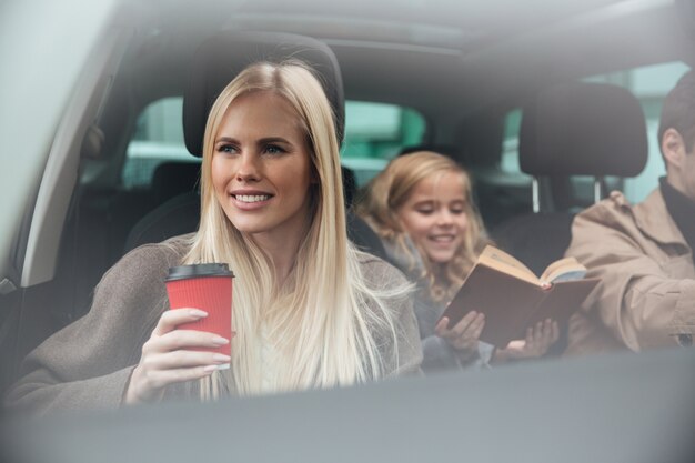 Cheerful young woman sitting in car