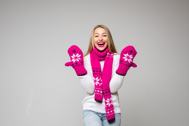 Cheerful young woman wearing matching scarf and mittens and feeling excited about holiday season. Holiday concept