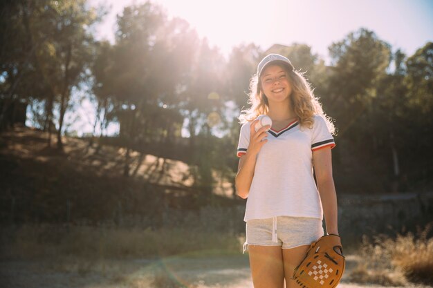 野球のグローブを持つ陽気な若い女性