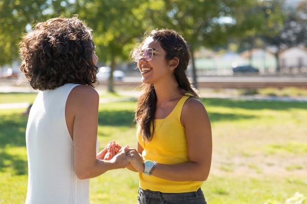 Cheerful young women meeting in park