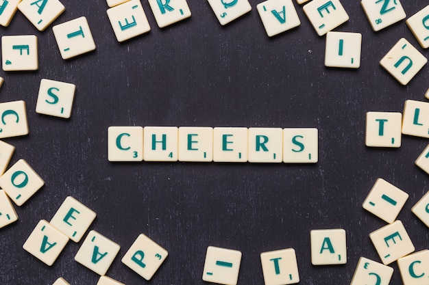 Cheers scrabble letters over black background