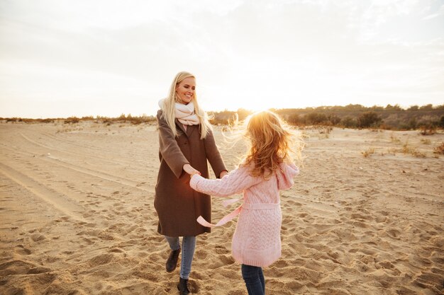 Cheery mother playing with her little daughter