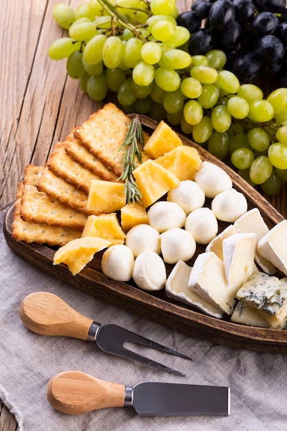 Cheese assortment with black and white grapes