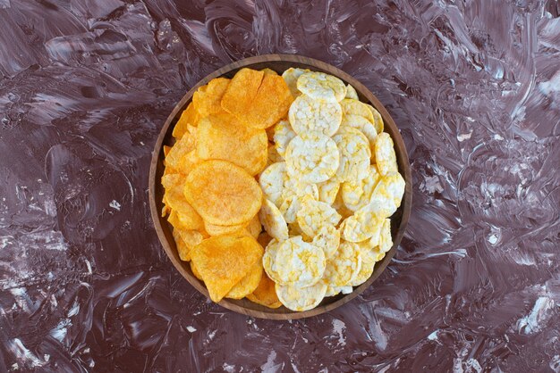 Cheese chips and potato chips in plate, on the marble table. 