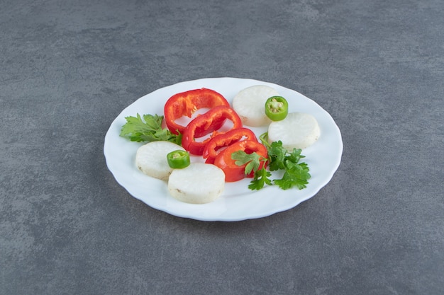 Cheese and pepper slices on white plate. 