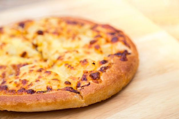 Cheese pizza on a wooden table close up