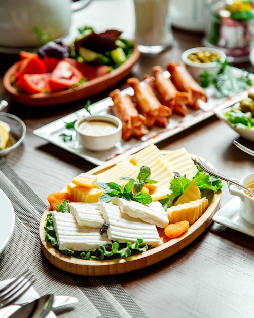 Cheese plate and sausages with vegetables