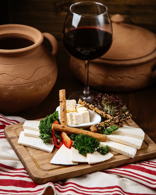 Free photo cheese plate with crispy bread and a glass of wine