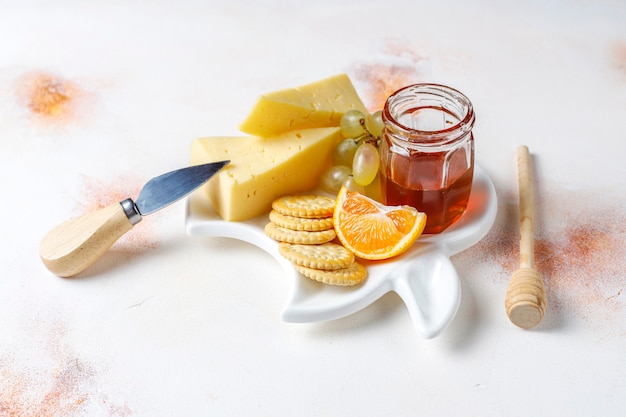 Бесплатное фото Сырная тарелка с восхитительным сыром тильзитер и закусками.