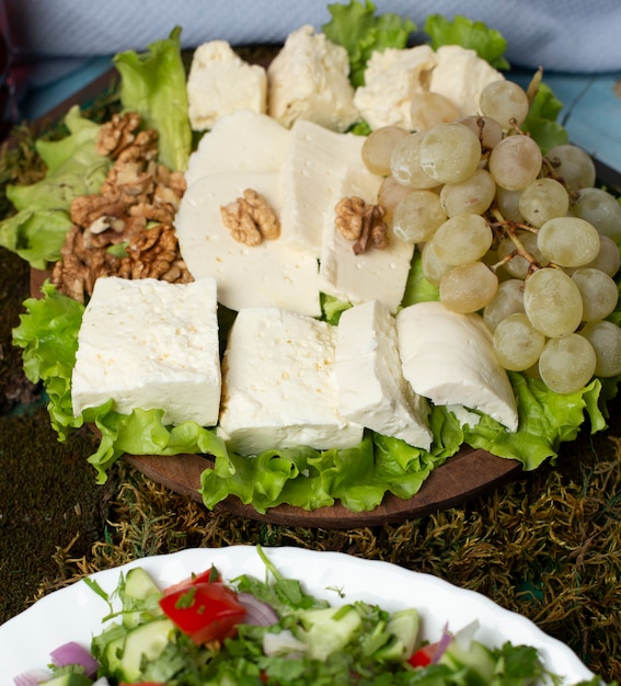 Cheese plate with green grapes and nuts.