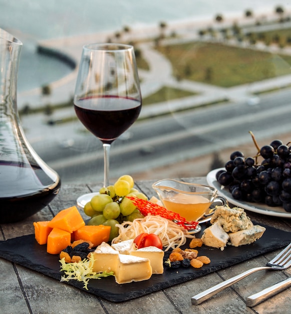 Foto gratuita piatto di formaggi con vino rosso