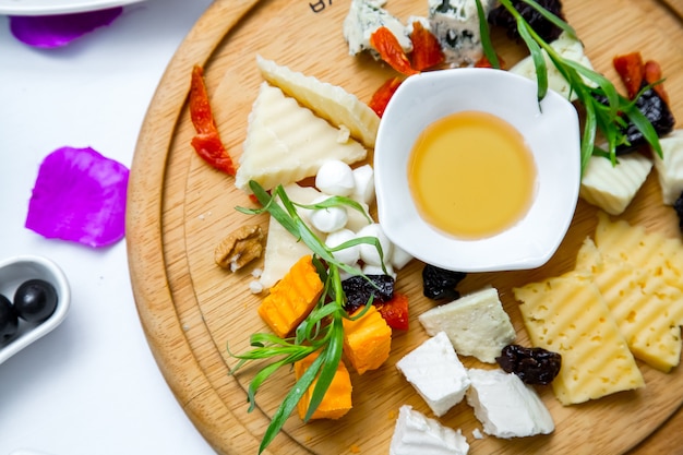 Cheese plate on the wooden board top view