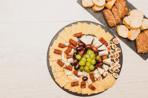 Cheese platter with grapes; smoked sausages and bread