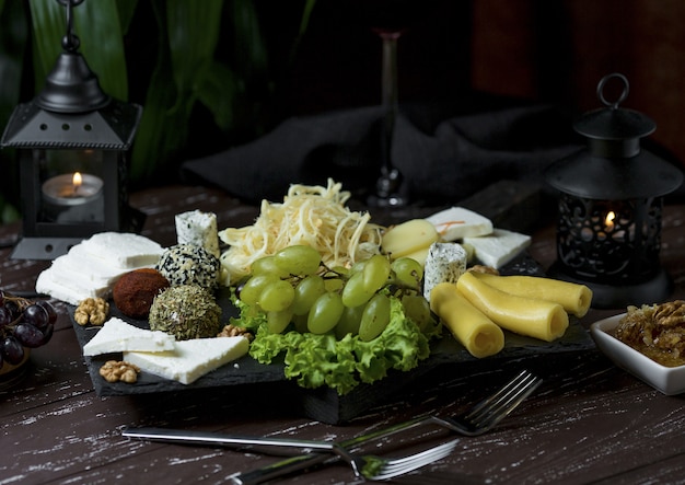 Cheese platter with sweets, nuts and green grapes