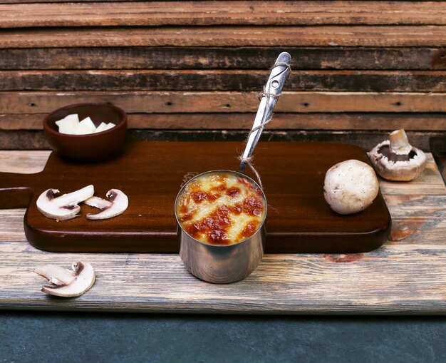 Free photo cheese sauce with mushroom in a metallic pan.