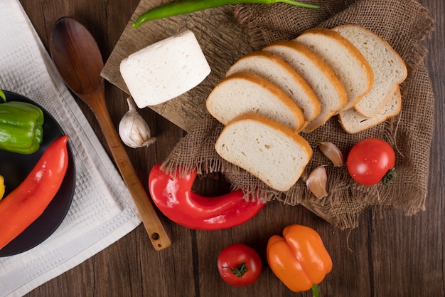 Cheese, sliced bread and colorful chilies. Top view