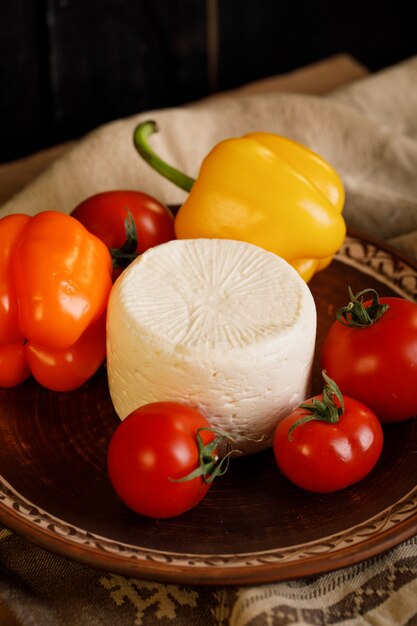 Cheese, tomatoes and peppers in a pottery plate