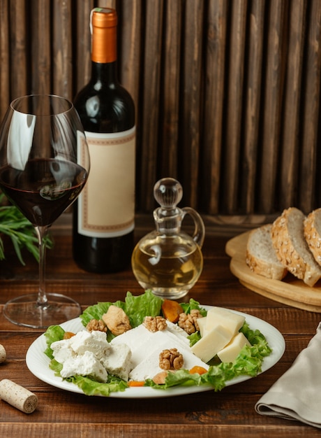 Cheese varieties served with walnuts and a glass of red wine