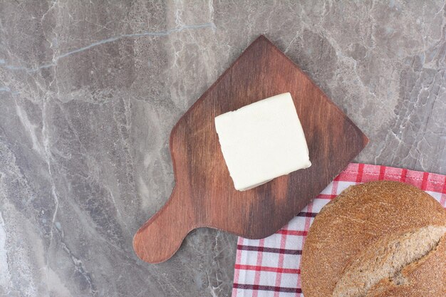 Cheese with brown bread on wooden board. High quality photo