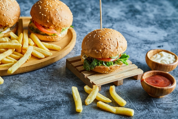 木の板にフライポテトとチーズバーガー