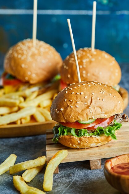 木の板にフライポテトとチーズバーガー