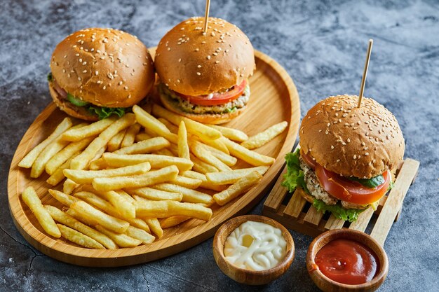 Cheeseburgers with fry potato on the wooden board 