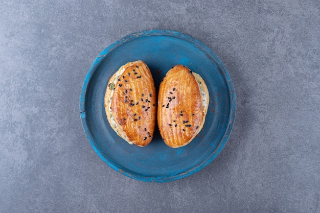 Foto gratuita pasticceria di formaggio sul piatto di legno sulla tavola di marmo.