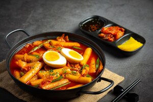 Cheesy tokbokki korean traditional food on black board background. lunch dish.