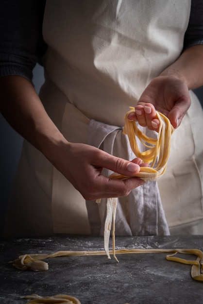 Chef Expertly Arranging Raw Pasta: A Mouthwatering Image