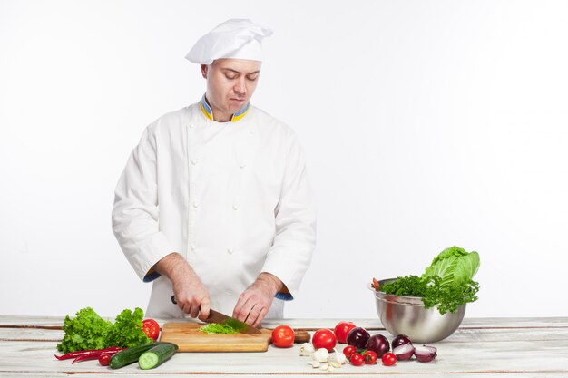 Шеф-повар готовит салат из свежих овощей на своей кухне