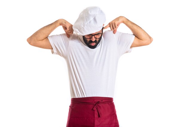 Chef covering his ears over white background