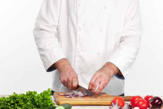 Chef cutting a onion on his kitchen