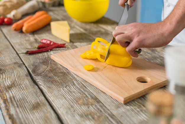 Chef cutting yellow pepper