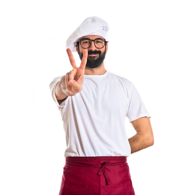 Chef doing victory gesture over white background