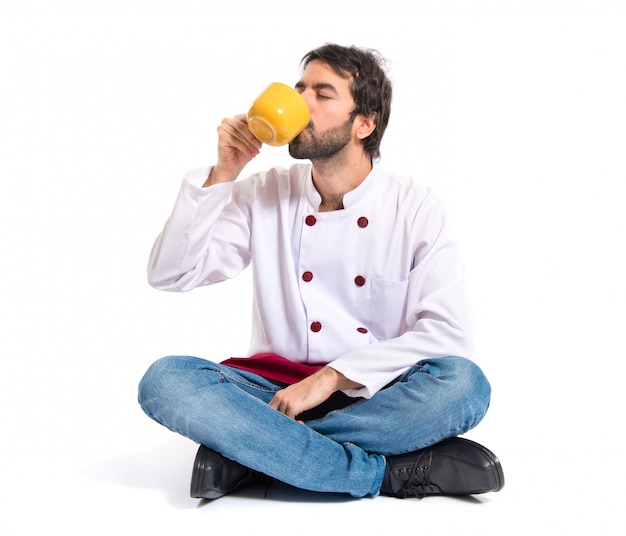 Chef drinking coffee over white background