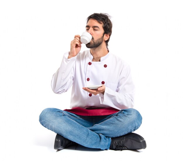 Chef drinking coffee over white background