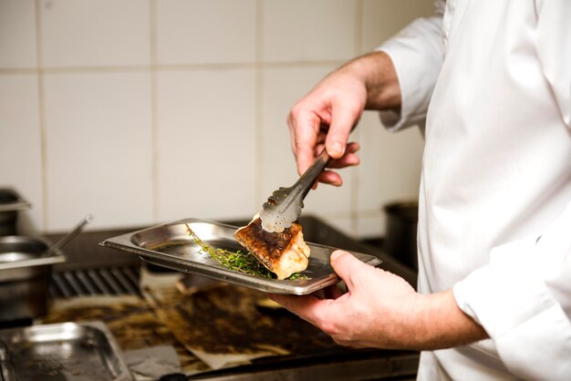 Chef frying fish side view