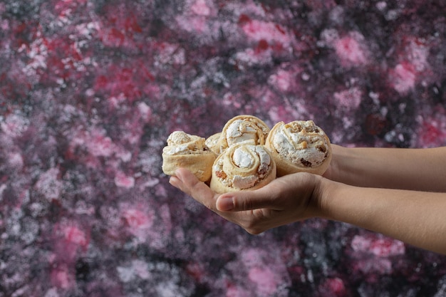 Free photo chef holding crispy cookies with sugar powder in the hand.